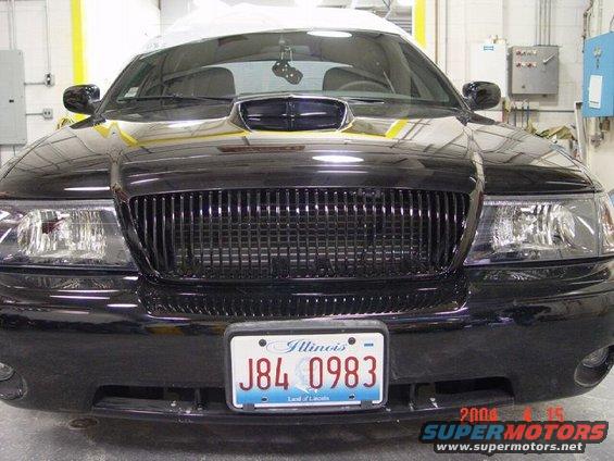 Black sedan front view showing custom grille and hood scoop. Illinois license plate J84 0983 visible