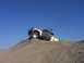 2000 Ford F-450 - A 2000 Ford F-450 is stuck on a sand dune with its driver's door open.