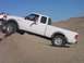 2000 Ford F-450 - White Ford Ranger pickup truck navigates a challenging off-road terrain with a second vehicle nearby.