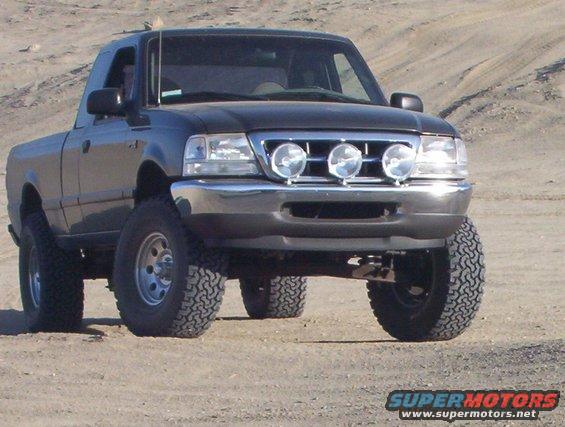 Black pickup truck with auxiliary lights and off-road tires