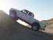 2000 Ford F-450 - A white pickup truck navigates a steep sand dune under a bright sky.
