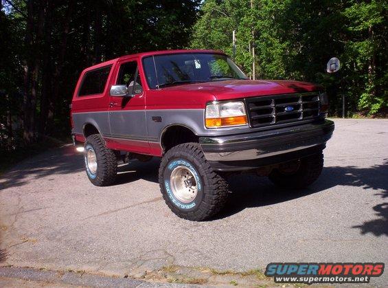 Red and grey 1995 Ford Bronco with aftermarket wheels and tires