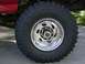 1996 Ford Bronco - Close-up of a chrome wheel and BFGoodrich Krawlers tire on a red vehicle.