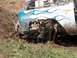 1979 Ford Bronco - Vehicle stuck in the mud, front fender damaged with blue flame graphics.