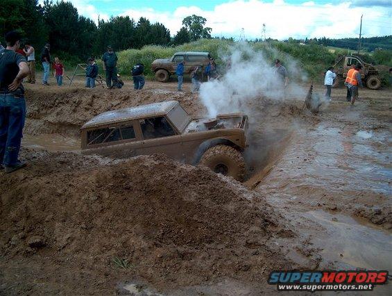 1979 Ford Bronco stuck in mud, steam rising from engine bay