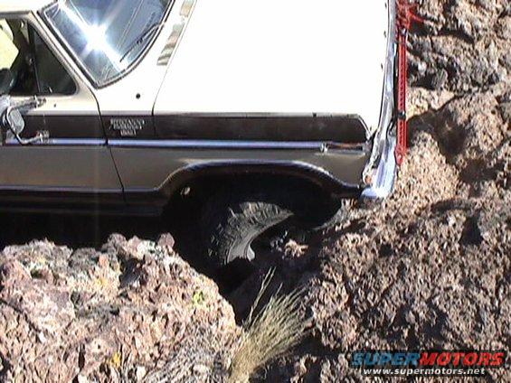 Side view of a 1979 Ford Bronco driving over rocks