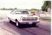 1967 Ford Fairlane - A white 1967 Ford Fairlane is captured on the drag strip, a prominent hood scoop and racing decals.