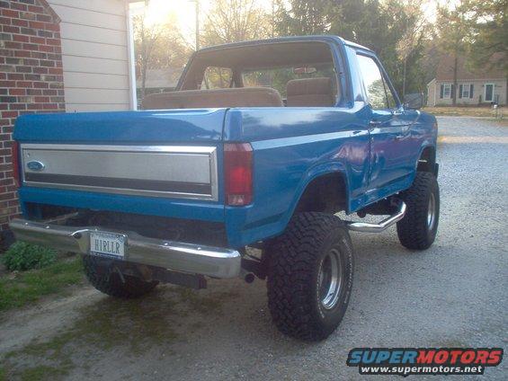Blue lifted 1980 Ford Bronco rear 3/4 view with chrome bumper and aftermarket wheels