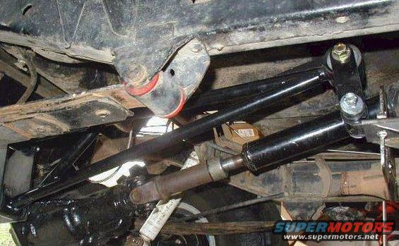 Underbody view of suspension linkage and drive shaft with red bushings