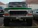 1979 Ford Bronco - This green 1979 Ford Bronco features a lifted suspension and prominent off-road tires, seen from a direct front-facing perspective.