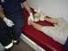 1990 Ford Bronco - A person lies on a red examination table while a paramedic checks their leg, which has a pencil embedded in it.