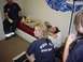 1990 Ford Bronco - Firefighters are seen attending to a patient lying on a medical cot in what appears to be a clinic or station.