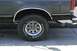 1989 Ford Bronco - Close-up of the rear wheel and fender of an SUV, showing the tire and exhaust pipe.