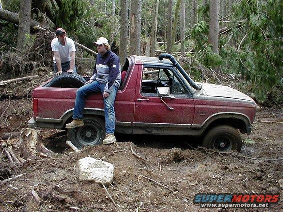 1983 Ford Bronco stuck in mud with snorkel, two men nearby