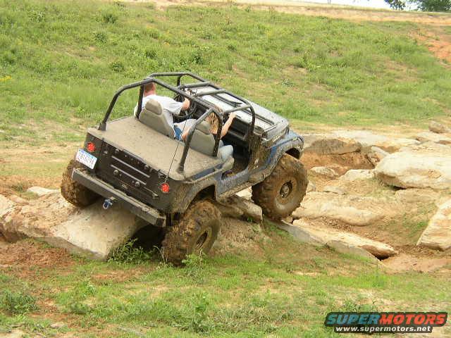 Jeep Wrangler climbing over rocks on an off-road trail
