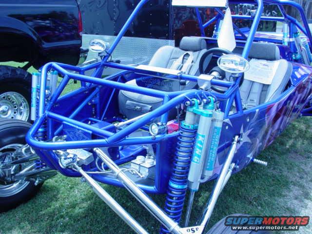 Blue off-road buggy with custom star graphics, chrome suspension, and racing shocks