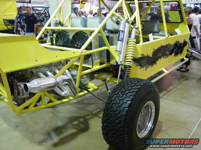 Yellow off-road buggy with exposed engine, roll cage, and Fox shocks