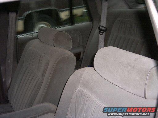 Back seat and headrests of a car interior. Seatbelts are visible