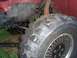 1989 Jeep YJ - Close-up of the front tire and suspension of a red Jeep YJ.