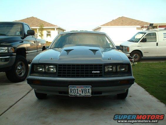 Gray 1979 Ford Mustang with a large hood scoop and aftermarket grille, front view