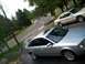 1999 Audi A6 - Two sedans are parked on a residential street and driveway on a cloudy day.
