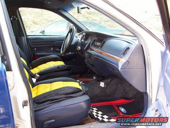 Interior of a 1995 Ford Crown Victoria showing front seats with yellow and black covers, dashboard, and steering wheel