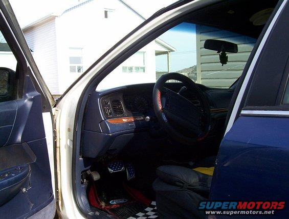 Interior view of a 1995 Ford Crown Victoria showing the dashboard, steering wheel, and driver's side door