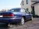 1995 Ford Crown Victoria - The rear of a blue 1995 Ford Crown Victoria sedan is visible, emitting smoke from the exhaust pipe.