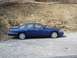 1995 Ford Crown Victoria - Blue 1995 Ford Crown Victoria parked on a gravel lot with a rocky hillside in the background.