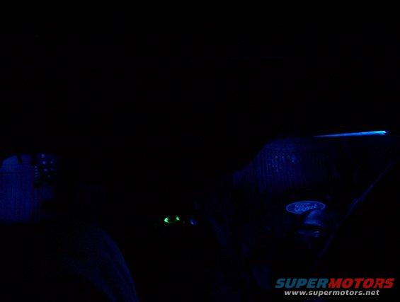 Ford emblem lit up blue on a dark surface, possibly a car interior