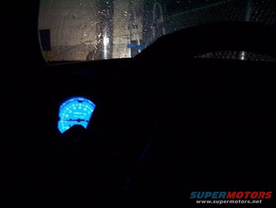 Dashboard interior with illuminated blue gauge at night