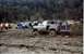 1990 Ford Bronco - Several trucks are stuck in deep mud during an off-road event.