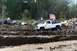 1990 Ford Bronco - Several trucks and spectators gather for a mud bogging event, with one white pickup truck stuck in the mire.