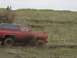 1981 Ford Bronco - Red SUV navigates a muddy terrain with a black hardtop.