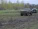 1981 Ford Bronco - Two off-road vehicles navigate a muddy terrain under an overcast sky.