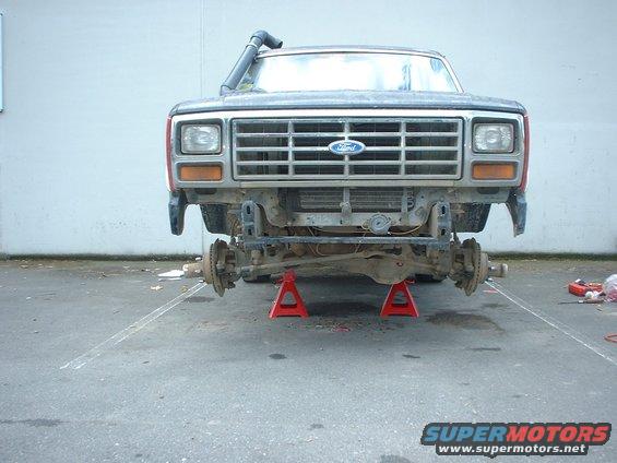 Ford truck front end on jack stands, missing bumper and fenders, snorkel visible