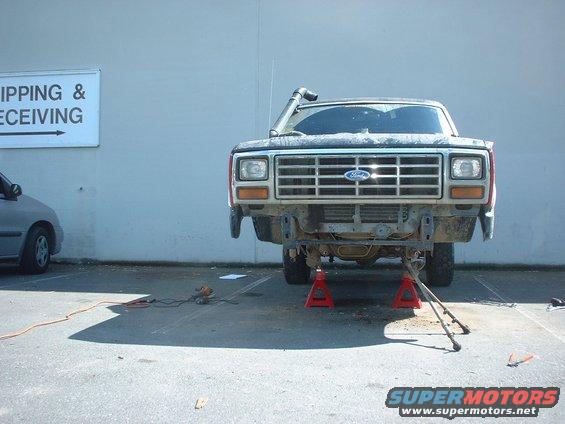 Front view of a Ford truck on red jack stands, with a snorkel. The bumper is removed