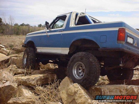 Blue and white Ford Bronco navigating rocky terrain