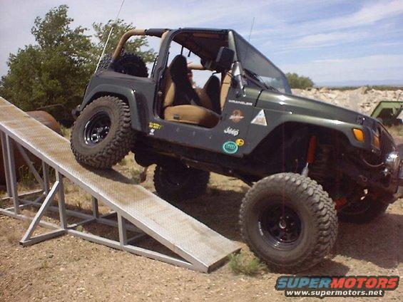 Green Jeep Wrangler climbing a metal ramp