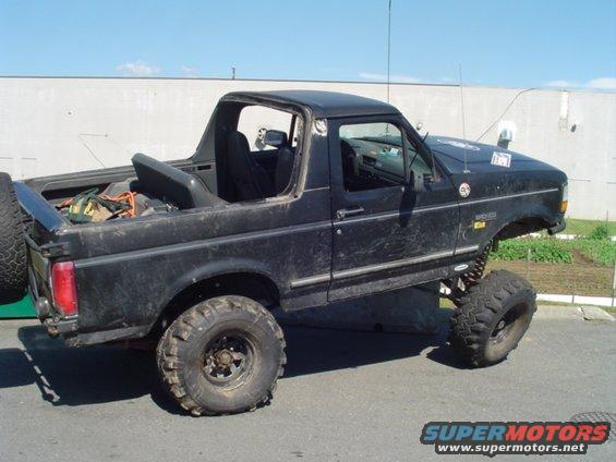 Black SUV with lifted suspension and off-road tires, top removed