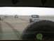 1978 Ford Bronco - Several vehicles drive across a wide, sandy beach under an overcast sky.