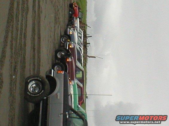 Line of SUVs and trucks parked on a dirt road, one with BFGoodrich tires