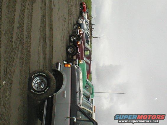 Gray 1978 Ford Bronco parked on a beach next to other vehicles