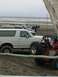 1978 Ford Bronco - Several vehicles are parked on the sand near the ocean, including a white Ford Bronco and a red dune buggy.
