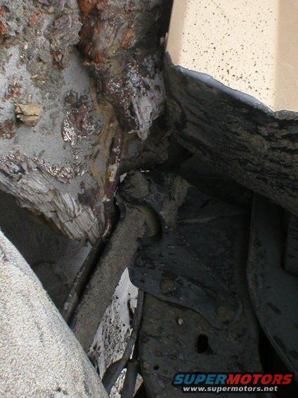 Close-up of heavily rusted metal structure and debris, possibly from a vehicle