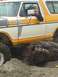 1978 Ford Bronco - This Ford Bronco is navigating over a large log, its off-road capabilities on a sandy surface.