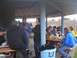 1978 Ford Bronco - A group of people are gathered for a meal at picnic tables under a covered outdoor shelter.