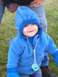 1978 Ford Bronco - A smiling baby in a blue hooded jacket and mittens is seen outdoors on a grassy area.