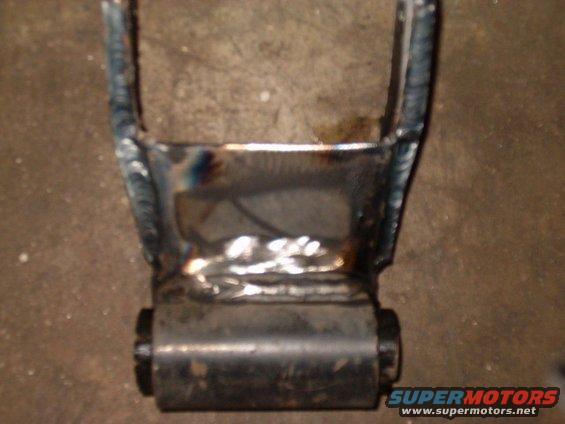Welded metal bracket with a black rubber bushing, viewed from the front