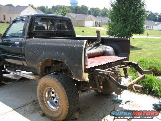 Black pickup truck, rear view, with bed removed and frame exposed